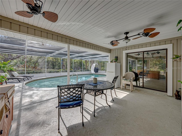 view of swimming pool featuring a patio, a water slide, ceiling fan, and a lanai