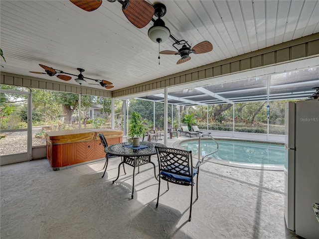 view of swimming pool with a patio area, ceiling fan, a lanai, and a hot tub