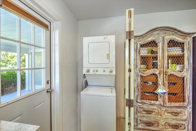 clothes washing area featuring stacked washer and clothes dryer