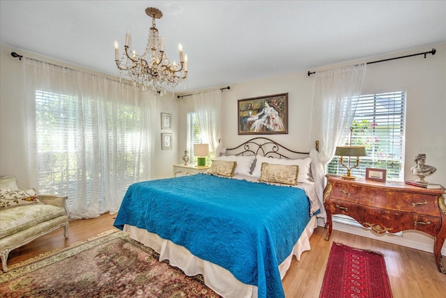 bedroom featuring light hardwood / wood-style floors and an inviting chandelier