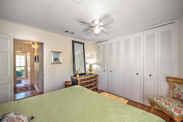 bedroom with a textured ceiling, a closet, and hardwood / wood-style floors