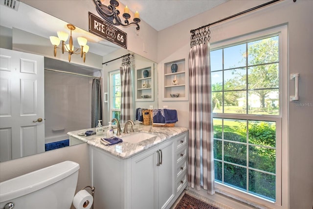 bathroom featuring toilet, vanity, and an inviting chandelier