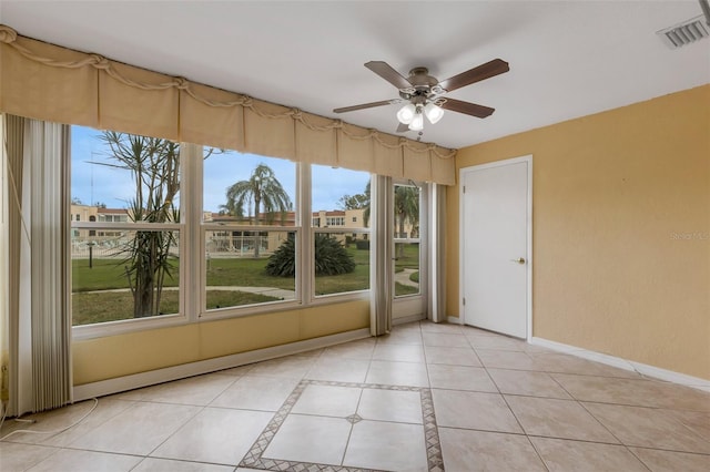 interior space featuring light tile patterned floors, baseboards, visible vents, and a wealth of natural light