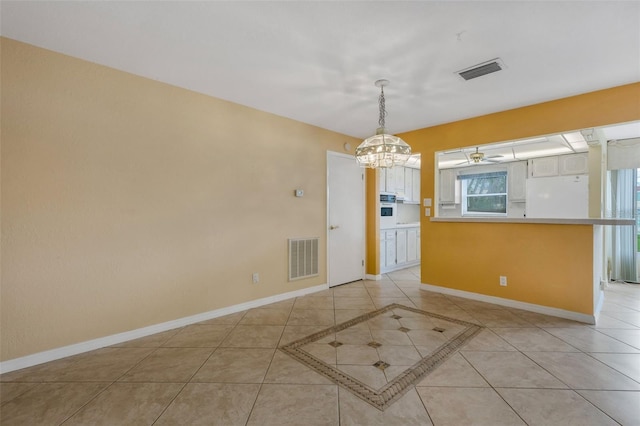 unfurnished dining area featuring light tile patterned floors, ceiling fan with notable chandelier, visible vents, and baseboards