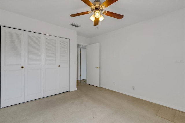 unfurnished bedroom with light carpet, baseboards, visible vents, a ceiling fan, and a closet