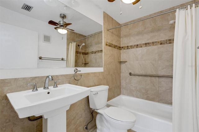 bathroom featuring toilet, a ceiling fan, visible vents, and tile walls