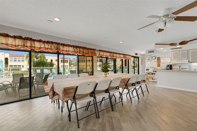 dining area featuring a textured ceiling, light wood finished floors, a ceiling fan, and recessed lighting