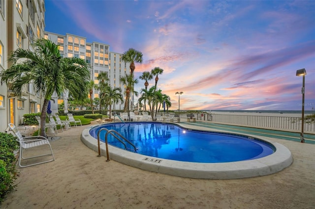 pool at dusk with a patio