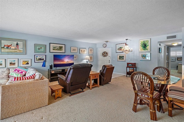 interior space featuring an inviting chandelier, light colored carpet, and a textured ceiling