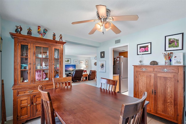 dining space with ceiling fan and light tile patterned floors