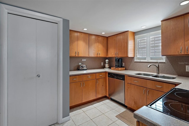 kitchen with sink, tasteful backsplash, light tile patterned floors, stainless steel dishwasher, and stove