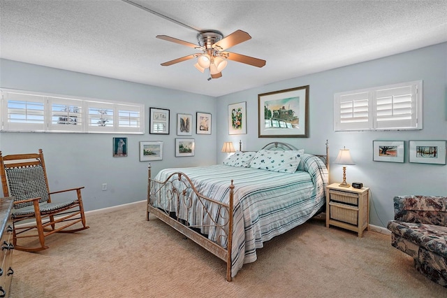 carpeted bedroom featuring multiple windows, ceiling fan, and a textured ceiling