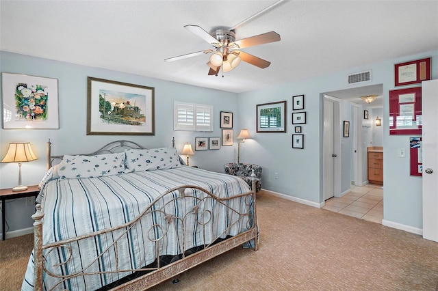 carpeted bedroom with ceiling fan and ensuite bath