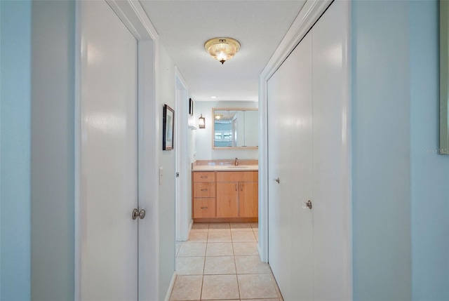 hallway with light tile patterned floors and sink