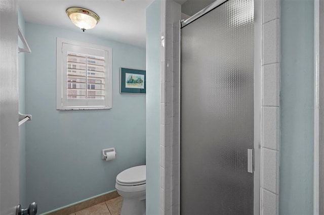 bathroom with tile patterned flooring, a shower with shower door, and toilet