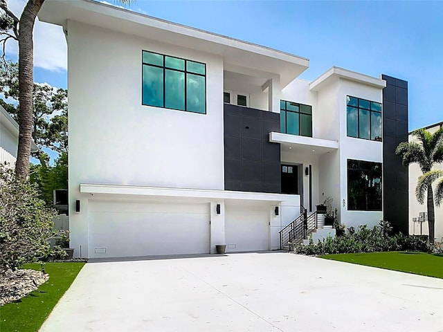 modern home with a garage, driveway, and stucco siding