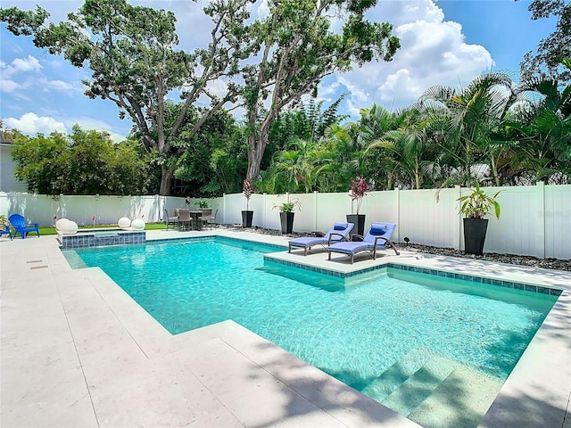 view of pool featuring a patio area, a jacuzzi, a fenced backyard, and a fenced in pool