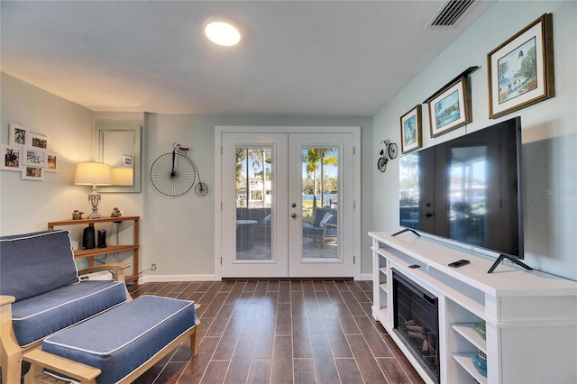 living area with baseboards, visible vents, wood finish floors, and french doors