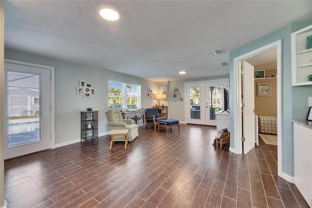 living area featuring french doors, dark wood finished floors, visible vents, and baseboards