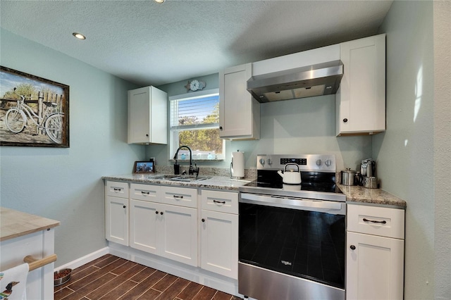 kitchen with a sink, white cabinetry, wood tiled floor, wall chimney exhaust hood, and stainless steel range with electric stovetop