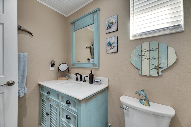 bathroom with toilet, vanity, and crown molding