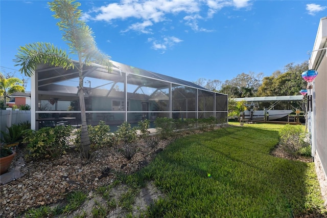 view of yard featuring glass enclosure and fence