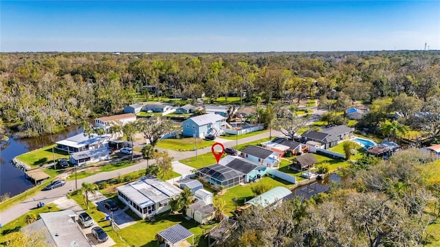 birds eye view of property featuring a residential view, a water view, and a view of trees