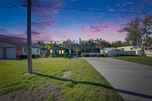 view of front of property featuring a lanai, driveway, and a front lawn