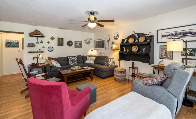 living area with a textured ceiling, wood finished floors, and a ceiling fan