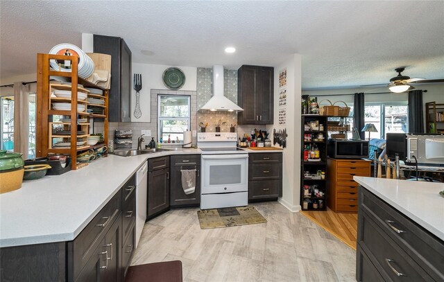 kitchen featuring a sink, white appliances, wall chimney exhaust hood, and light countertops