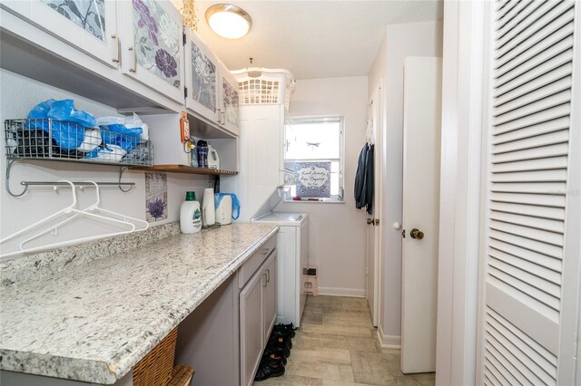 laundry area featuring cabinet space and baseboards