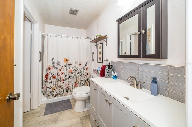 full bath featuring visible vents, toilet, curtained shower, a textured ceiling, and vanity