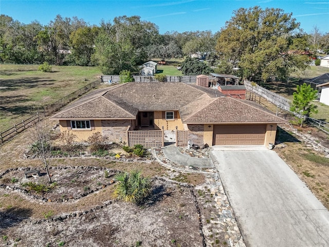 view of front of home with stucco siding, an attached garage, driveway, and fence