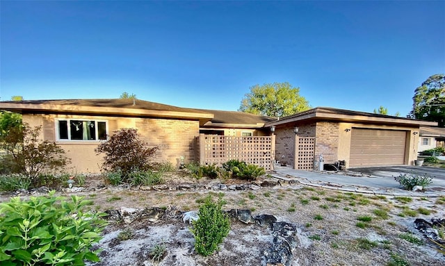ranch-style house featuring an attached garage and aphalt driveway