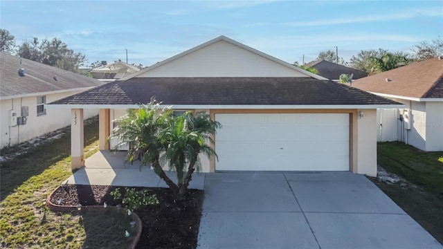 view of side of home featuring a garage, concrete driveway, and a shingled roof