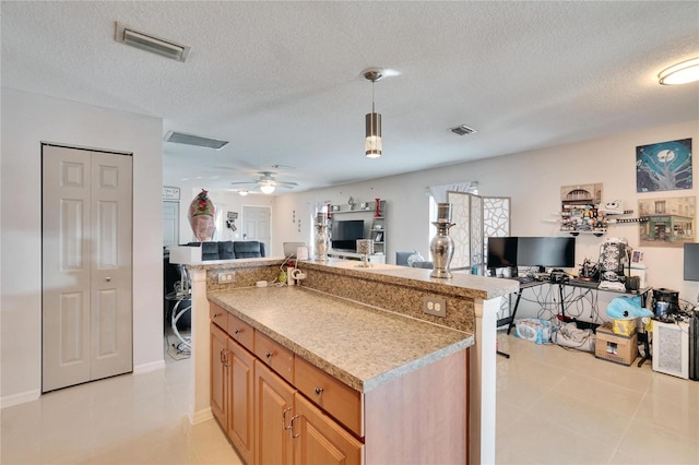 kitchen with visible vents, open floor plan, decorative light fixtures, and light brown cabinetry