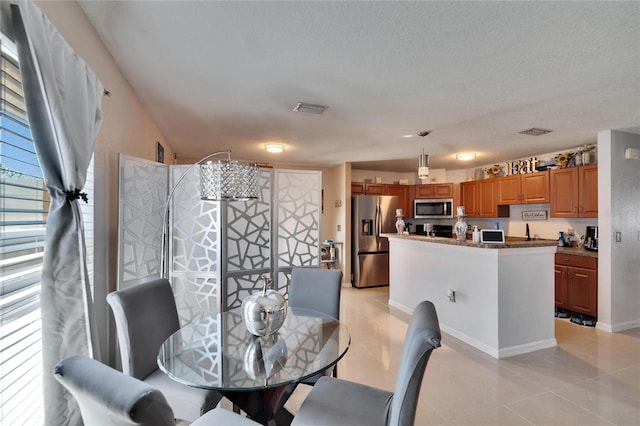 dining area with visible vents, a textured ceiling, and light tile patterned flooring