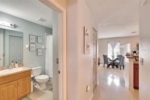 bathroom featuring visible vents, tile patterned floors, a textured ceiling, vanity, and a closet