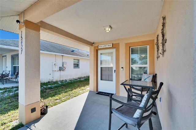 entrance to property with a patio area and stucco siding