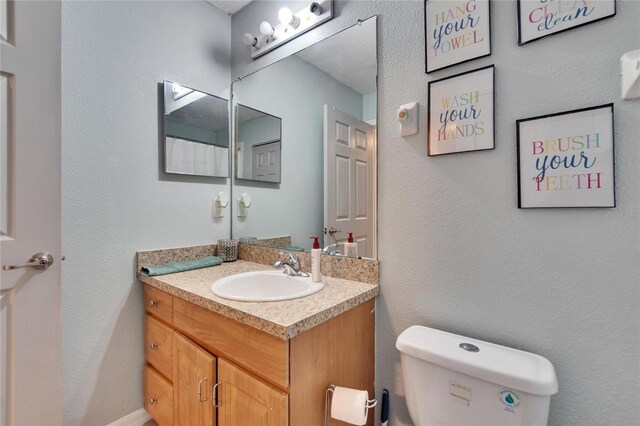 bathroom with toilet and vanity