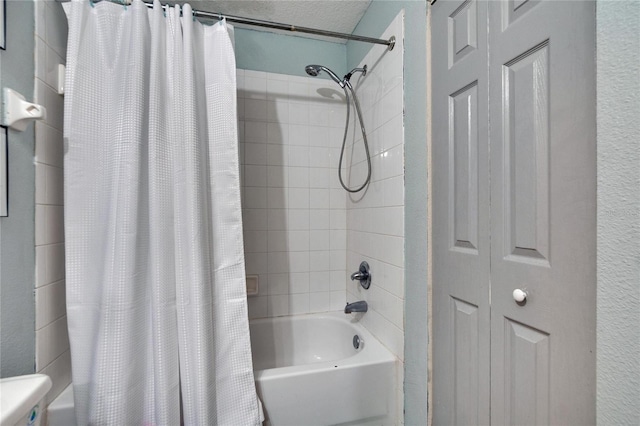 bathroom with a textured ceiling and shower / tub combo with curtain