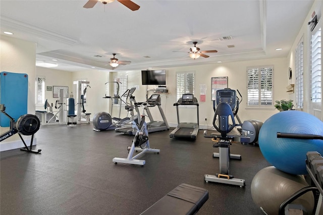 workout area featuring ornamental molding, a raised ceiling, visible vents, and baseboards