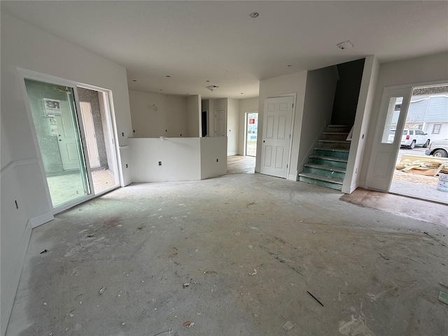 unfurnished living room with stairway