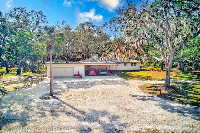 ranch-style home featuring a garage and a front lawn