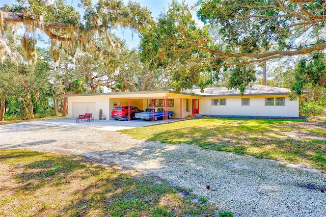 ranch-style home with a carport, a garage, and a front yard