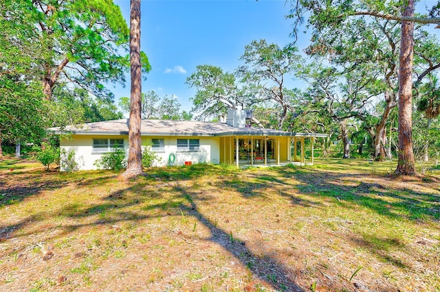 rear view of property featuring a lawn