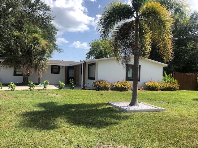 single story home featuring a front yard, fence, and stucco siding