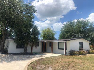 ranch-style home with driveway, a front yard, and stucco siding