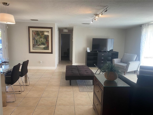 907 Fruitland Ave, Bradenton, FL 34207 - living room with light tile patterned floors, baseboards, visible vents, rail lighting, and a textured ceiling