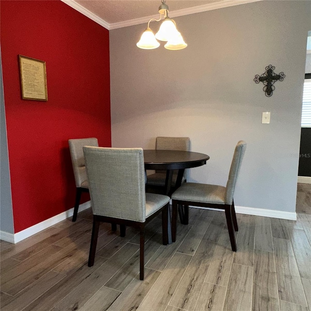 dining area with crown molding, an inviting chandelier, and hardwood / wood-style flooring